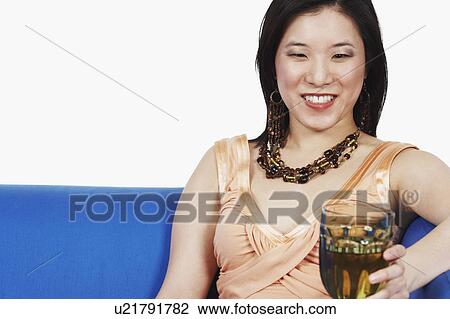 Close-up of a young woman holding a glass of red wine View Large Photo Image Stock Image - Close-up of a young woman holding a glass of red wine. Fotosearch