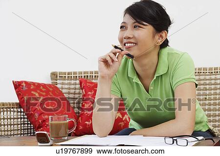 Close-up of a young woman leaning against a table and thinking View Large Photo Image Stock Photo - Close-up of a young woman leaning against a table and thinking. Fotosearch