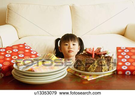Stock Photo - Girl looking at a cake. Fotosearch
