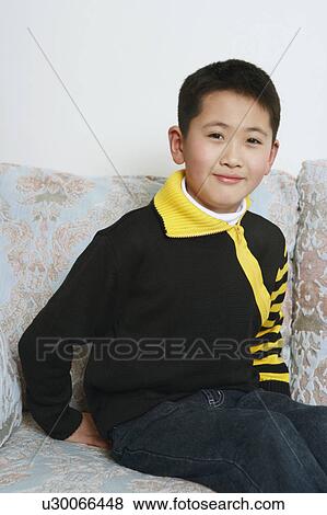 Portrait of a boy sitting on a couch View Large Photo Image Stock Photo - Portrait of a boy sitting on a couch. Fotosearch