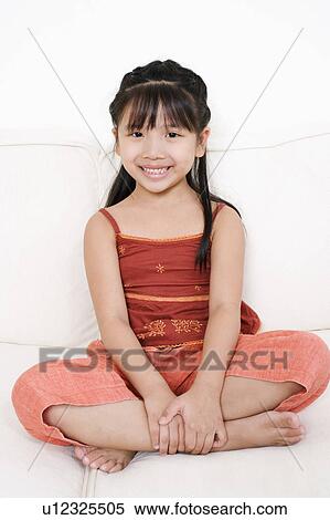 Portrait of a girl sitting on a couch View Large Photo Image Stock Photography - Portrait of a girl sitting on a couch. Fotosearch