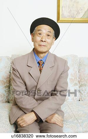 Stock Image - Portrait of a senior man sitting on a couch. Fotosearch