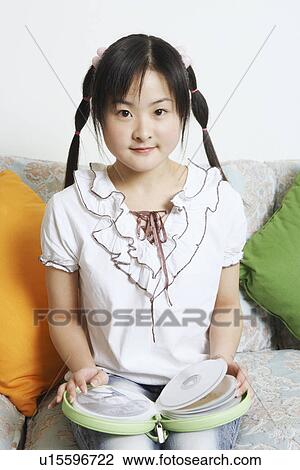 Portrait of a young woman holding a CD case View Large Photo Image Stock Image - Portrait of a young woman holding a CD case. Fotosearch