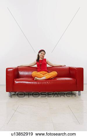 Portrait of a young woman resting on a couch View Large Photo Image Stock Photo - Portrait of a young woman resting on a couch. Fotosearch