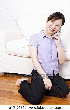 Stock Image - Portrait of a young woman talking on a mobile phone. Fotosearch