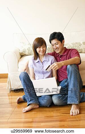 Stock Photo - Young couple shopping online with a credit card. Fotosearch