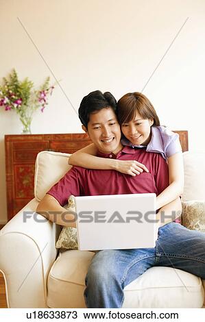 Young couple using a laptop and smiling View Large Photo Image Stock Image - Young couple using a laptop and smiling. Fotosearch