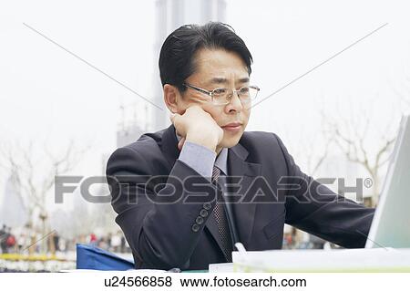 Stock Photo - Close-up of a businessman using a laptop. Fotosearch