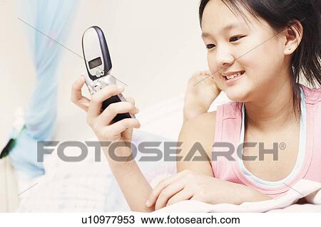 Stock Image - Close-up of a girl holding a mobile phone. Fotosearch