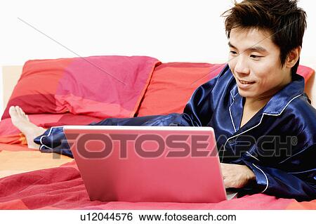 Close-up of a mid adult man using a laptop View Large Photo Image Stock Photograph - Close-up of a mid adult man using a laptop. Fotosearch