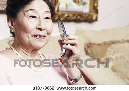 Close-up of a senior woman holding a mobile phone View Large Photo Image Stock Image - Close-up of a senior woman holding a mobile phone. Fotosearch
