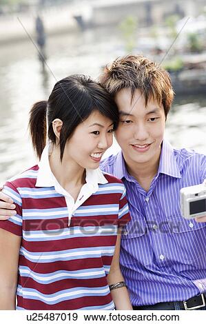 Close-up of a young couple taking a picture of themselves View Large Photo Image Stock Photo - Close-up of a young couple taking a picture of themselves. Fotosearch