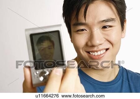 Stock Photograph - Close-up of a young man taking a picture of himself . Fotosearch