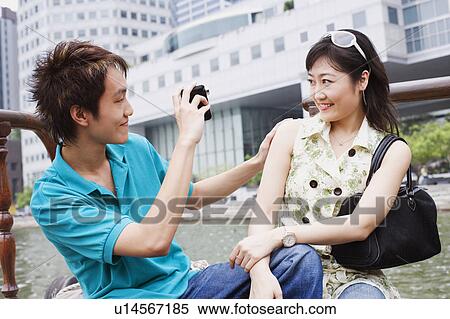 Close-up of a young man taking video of a young woman View Large Photo Image Stock Photography - Close-up of a young man taking video of a young woman. Fotosearch