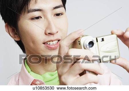 Close-up of a young man using a digital camera View Large Photo Image Stock Image - Close-up of a young man using a digital camera. Fotosearch