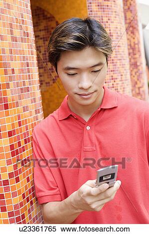 Close-up of a young man using a mobile phone View Large Photo Image Stock Photography - Close-up of a young man using a mobile phone. Fotosearch