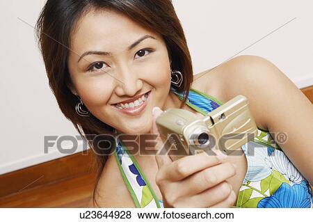 Close-up of a young woman holding a digital camera View Large Photo Image Stock Photo - Close-up of a young woman holding a digital camera. Fotosearch