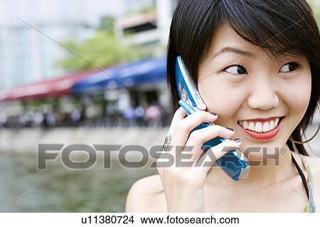 Picture - Close-up of a young woman talking on a mobile phone. Fotosearch