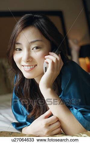 Stock Image - Close-up of a young woman talking on a mobile phone. Fotosearch