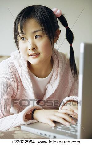 Picture - Close-up of a young woman using a laptop. Fotosearch