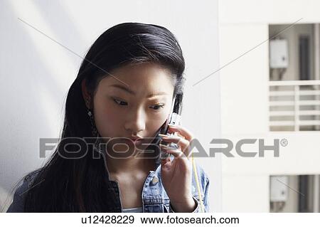 Close-up of a young woman using a mobile phone View Large Photo Image Stock Photo - Close-up of a young woman using a mobile phone. Fotosearch