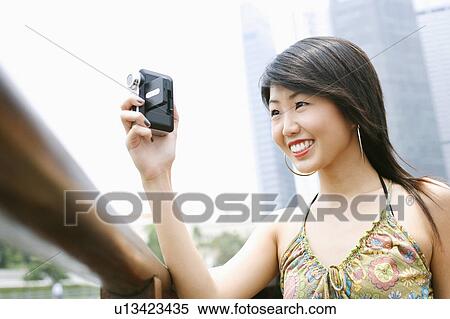 Close-up of a young woman using a video camera View Large Photo Image Stock Photography - Close-up of a young woman using a video camera. Fotosearch
