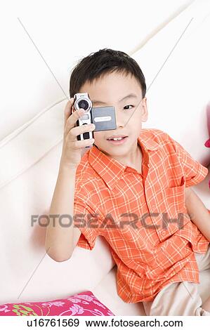 High angle view of a boy taking a photograph with a digital camera View Large Photo Image Stock Photo - High angle view of a boy taking a photograph with a digital camera. Fotosearch