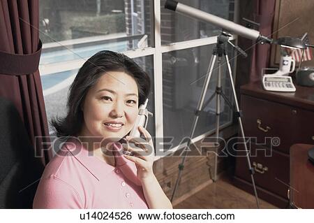 Portrait of a mature woman talking on a cordless telephone View Large Photo Image Stock Photograph - Portrait of a mature woman talking on a cordless telephone. Fotosearch