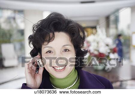 Portrait of a mature woman talking on a mobile phone View Large Photo Image Stock Photograph - Portrait of a mature woman talking on a mobile phone. Fotosearch