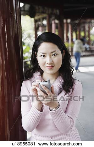 Portrait of a young woman operating a mobile phone with a digitized pen View Large Photo Image Stock Image - Portrait of a young woman operating a mobile phone with a digitized pen. Fotosearch