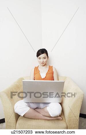 Stock Image - Portrait of a young woman using a laptop. Fotosearch