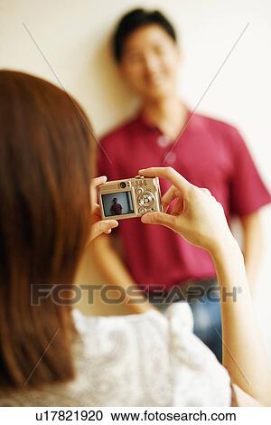 Rear view of a young man taking a picture of a young woman View Large Photo Image Stock Image - Rear view of a young man taking a picture of a young woman. Fotosearch
