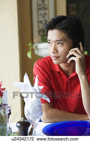 Young man talking on a mobile phone View Large Photo Image Stock Image - Young man talking on a mobile phone. Fotosearch
