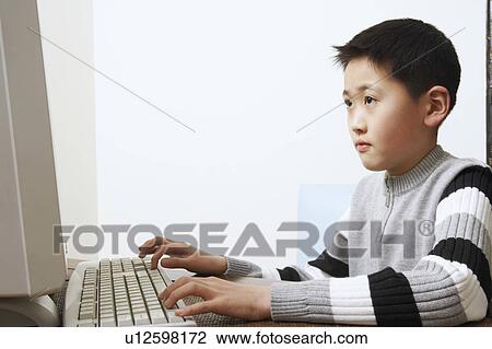Close-up of a boy using a computer View Large Photo Image Stock Image - Close-up of a boy using a computer. Fotosearch