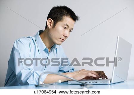 Close-up of a doctor operating a laptop View Large Photo Image Picture - Close-up of a doctor operating a laptop. Fotosearch