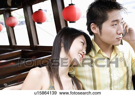 Close-up of a young man talking on mobile phone and a young woman resting her head on his shoulder View Large Photo Image Stock Photo - Close-up of a young man talking on mobile phone and a young woman resting her head on his shoulder. Fotosearch