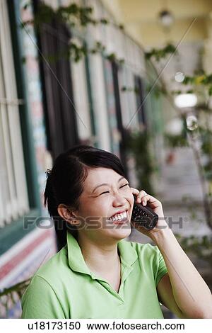 Close-up of a young woman talking on a cordless phone View Large Photo Image Stock Image - Close-up of a young woman talking on a cordless phone. Fotosearch