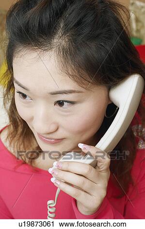 Close-up of a young woman talking on the telephone View Large Photo Image Stock Image - Close-up of a young woman talking on the telephone. Fotosearch
