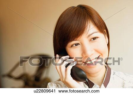 Close-up of a young woman talking on the telephone View Large Photo Image Stock Image - Close-up of a young woman talking on the telephone. Fotosearch