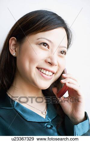 Close-up of a young woman talking on mobile phone View Large Photo Image Stock Photo - Close-up of a young woman talking on mobile phone. Fotosearch