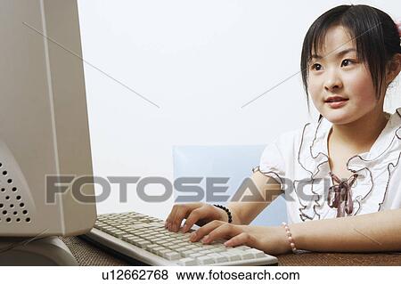Close-up of a young woman using a computer View Large Photo Image Stock Photo - Close-up of a young woman using a computer. Fotosearch