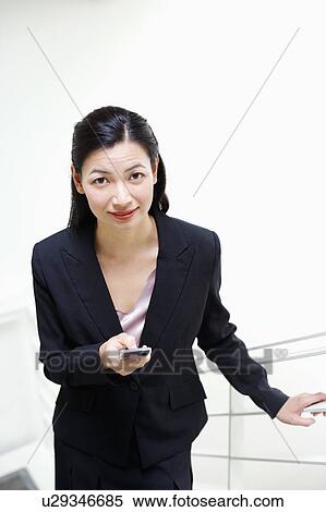Portrait of a businesswoman operating a mobile phone View Large Photo Image Stock Photography - Portrait of a businesswoman operating a mobile phone. Fotosearch