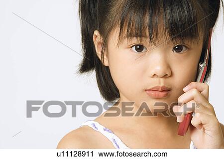 Stock Image - Portrait of a girl holding a mobile phone. Fotosearch