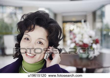 Stock Image - Portrait of a mature woman talking on a mobile phone. Fotosearch
