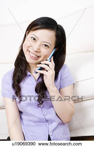 Portrait of a young woman talking on a mobile phone View Large Photo Image Stock Image - Portrait of a young woman talking on a mobile phone. Fotosearch