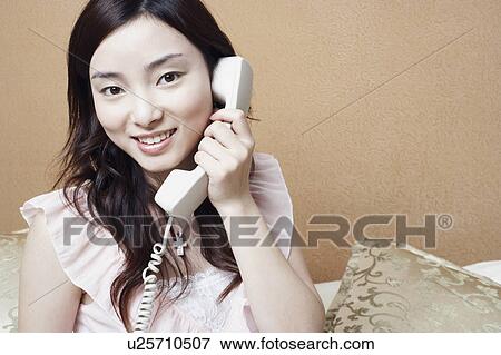 Portrait of a young woman talking on the telephone View Large Photo Image Stock Photo - Portrait of a young woman talking on the telephone. Fotosearch
