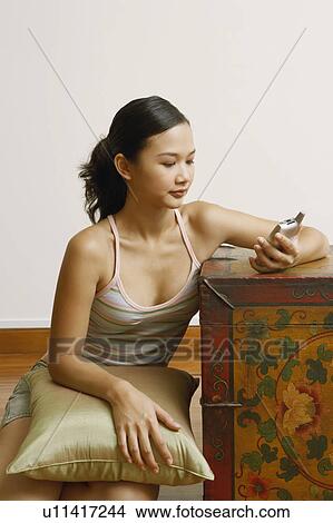 Young woman holding a mobile phone View Large Photo Image Picture - Young woman holding a mobile phone. Fotosearch