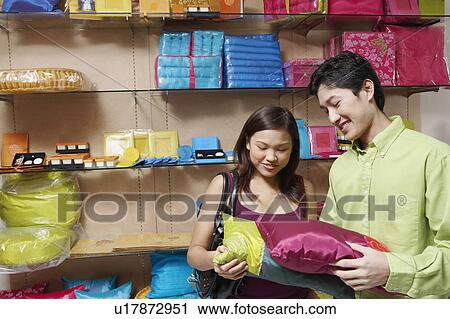 Close-up of a young couple choosing pillows in a store and smiling View Large Photo Image Stock Image - Close-up of a young couple choosing pillows in a store and smiling. Fotosearch