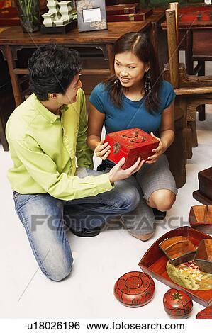 High angle view of a young couple choosing merchandise in a store View Large Photo Image Stock Photograph - High angle view of a young couple choosing merchandise in a store. Fotosearch