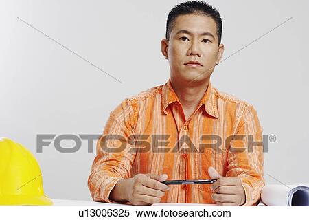 Stock Photography - Portrait of a male architect holding a pen. Fotosearch